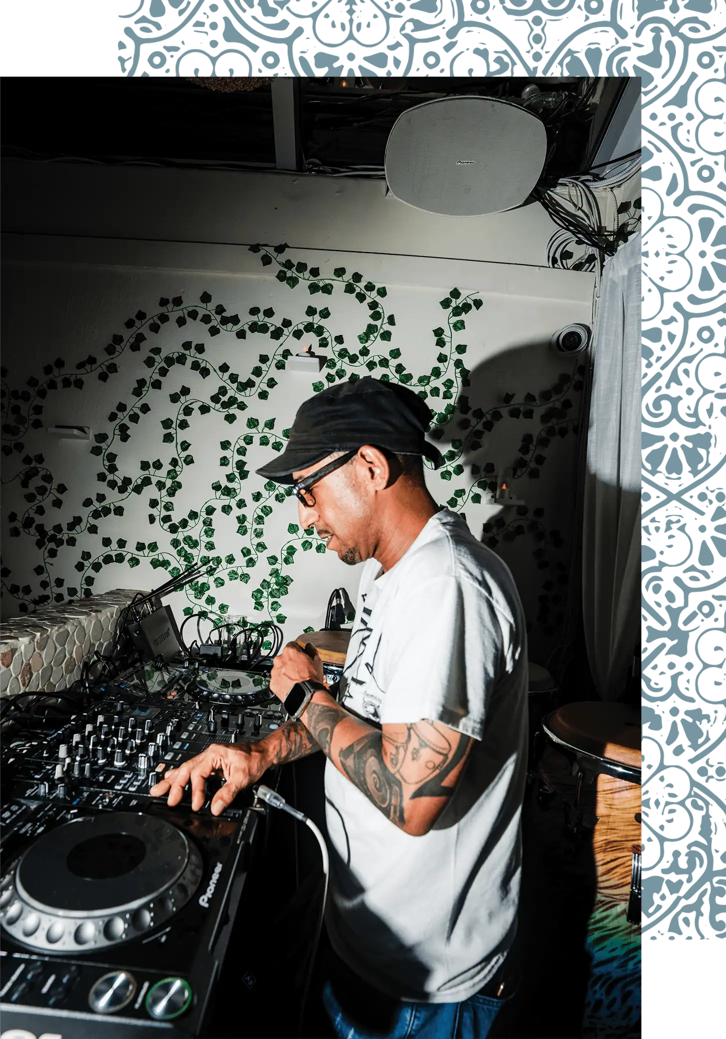 DJ performing music programming framed with ornamental design.